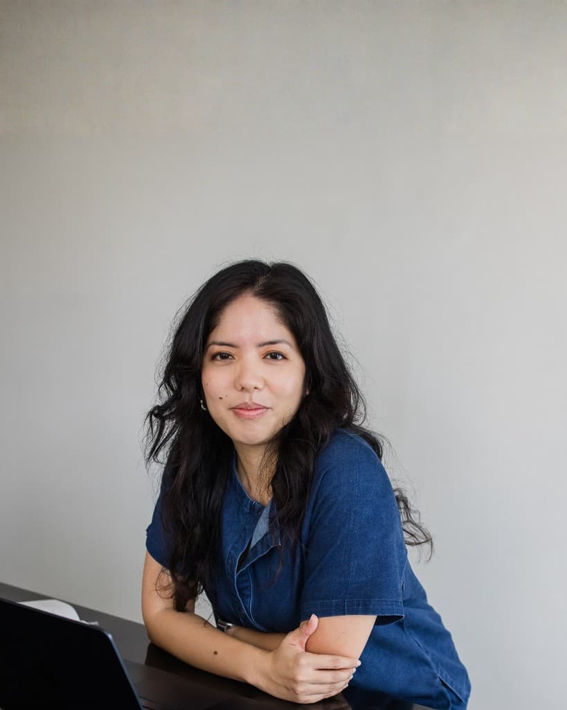 Niki, seated at a desk